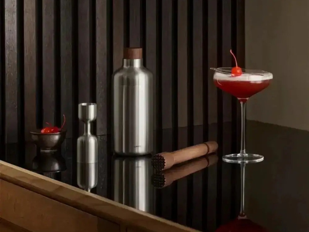 Eva Solo Liquid Lounge stainless steel cocktail shaker on a dark bar with a garnished coupe cocktail