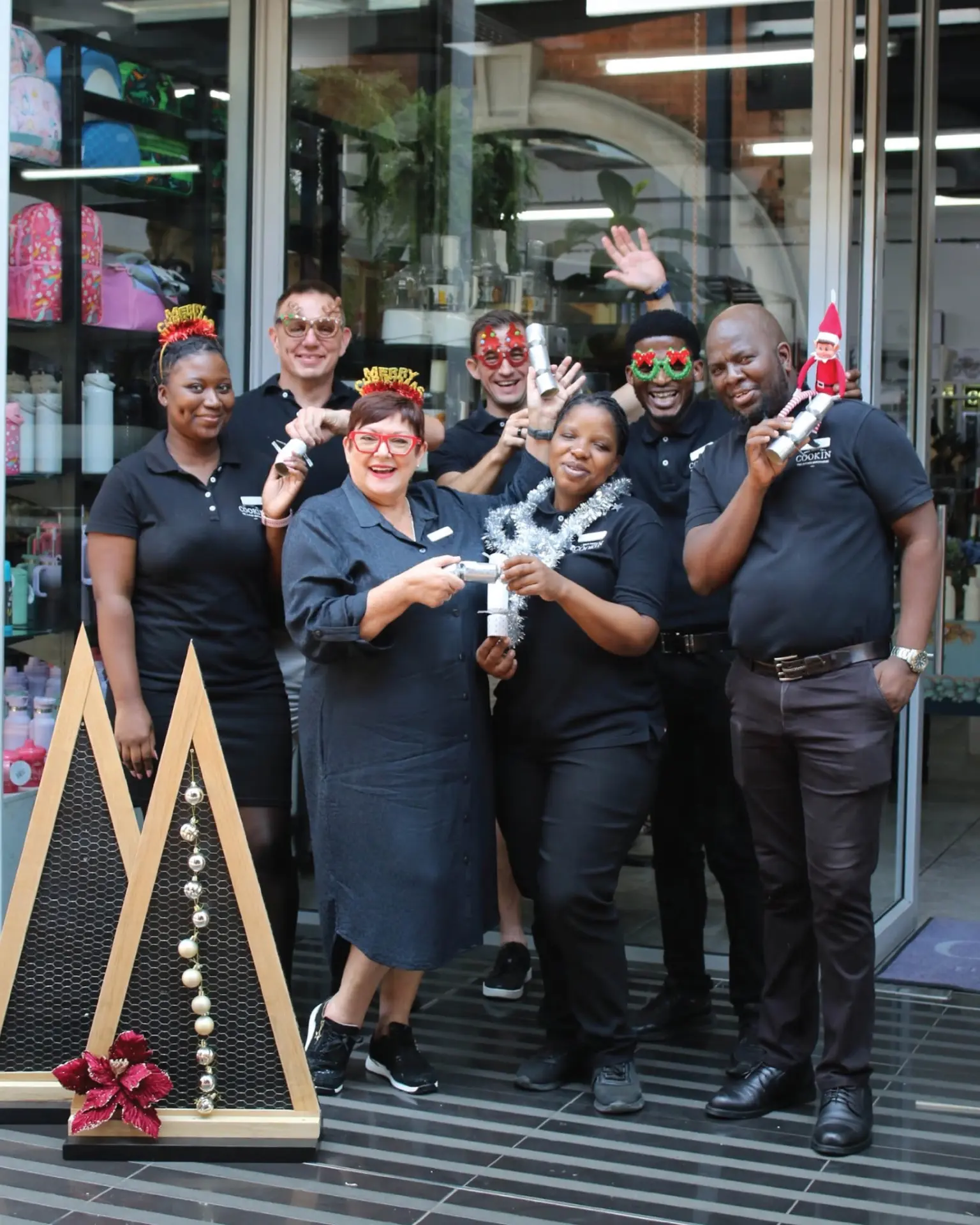 The Cookin team in branded black shirts, celebrating together outside the store